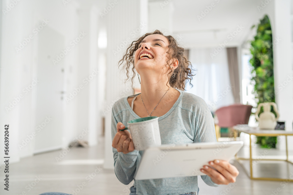 One woman young caucasian use digital tablet on the floor at home One woman young caucasian use digital tablet on the floor at home