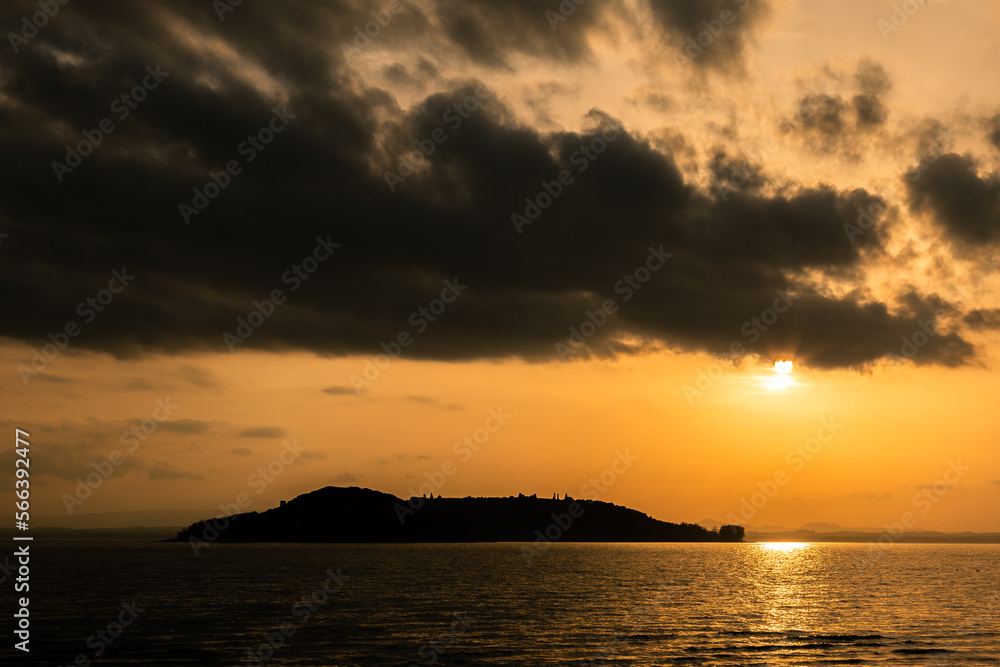 Lake at sunset with sun coming down off clouds and reflecting on water