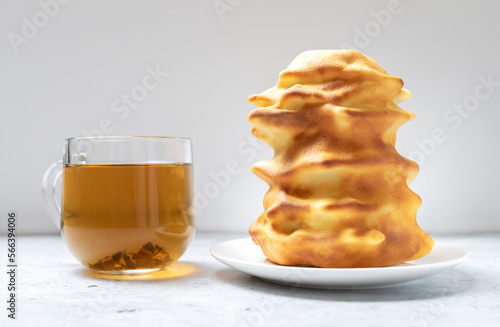 Sakotis ,sekacz, baumkuchen is traditional spit cake in lithuanian, polish, german, belarusian cuisine made of butter, eggs, flour, sugar cooked on rotating spit over open fire. Cup of tea. Horizontal photo