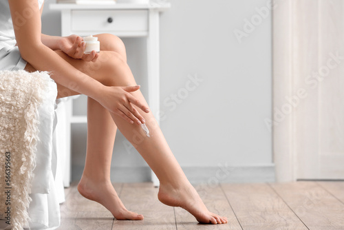 Woman applying cream onto h...