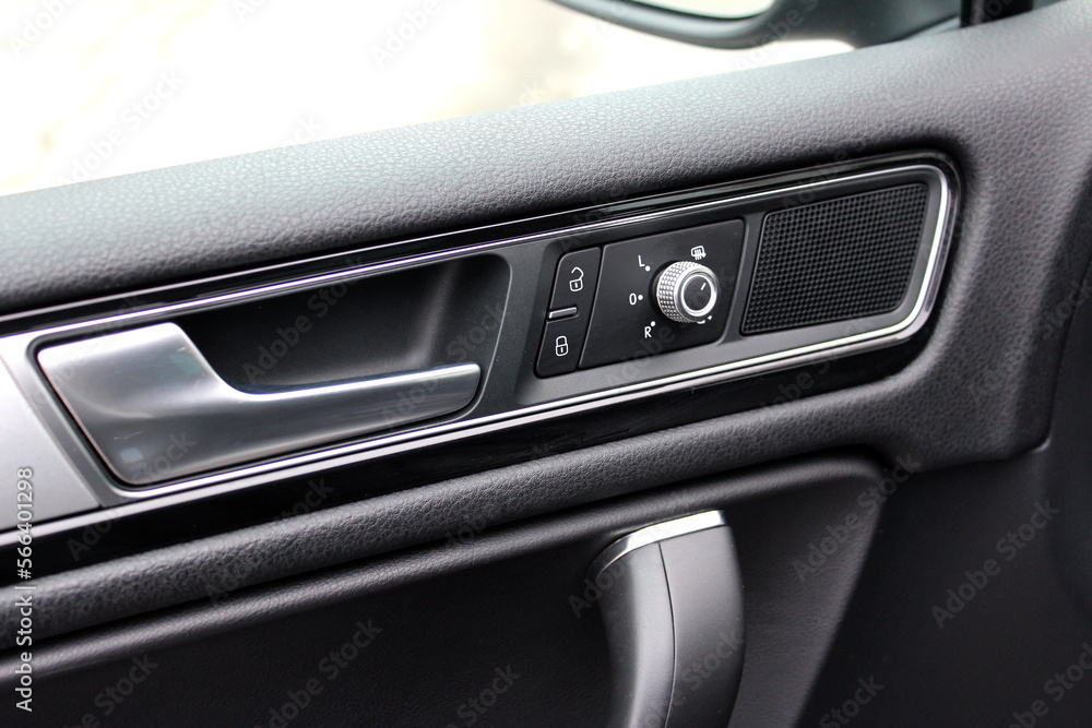 Door handle with mirrors controls and adjustments in modern car. Mirror switches. Driver door trim modern car.