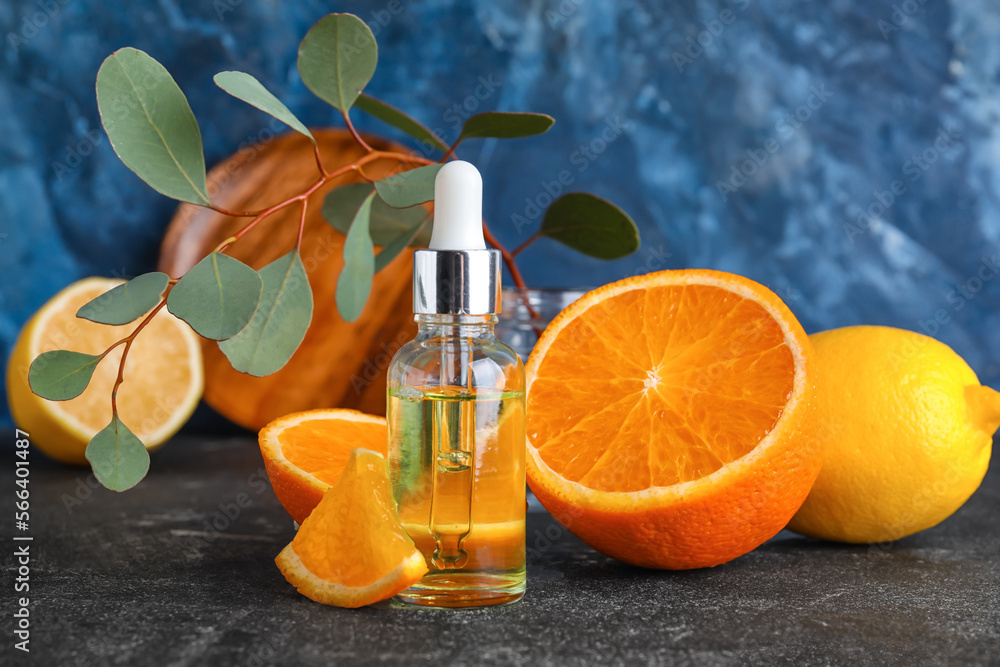 Bottle of healthy serum and fresh citrus fruits on table Bottle of healthy serum and fresh citrus fruits on table