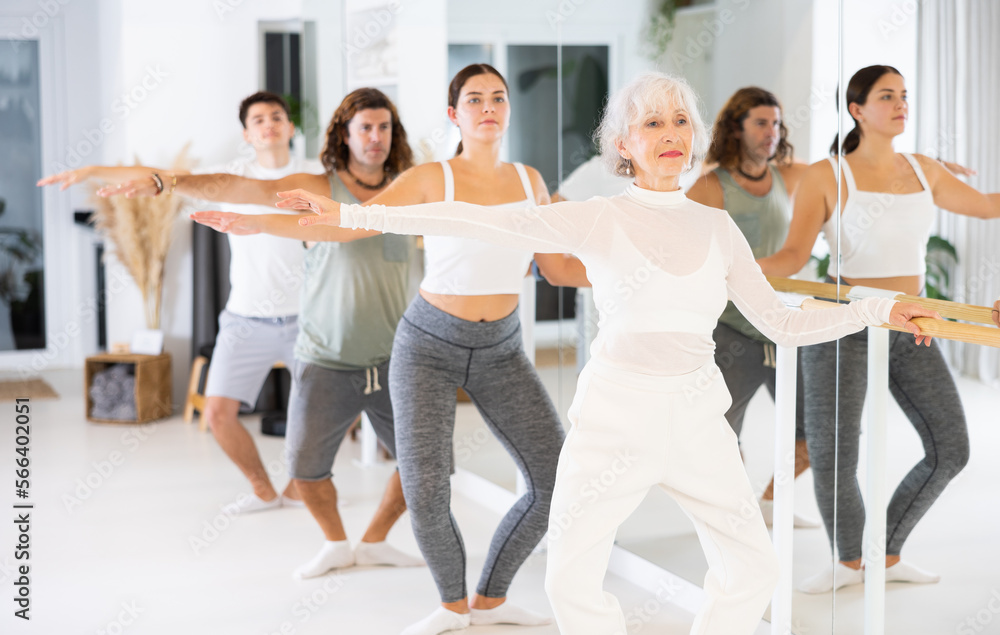 Fototapeta premium Group of people of different ages practice ballet moves in classical dance school.