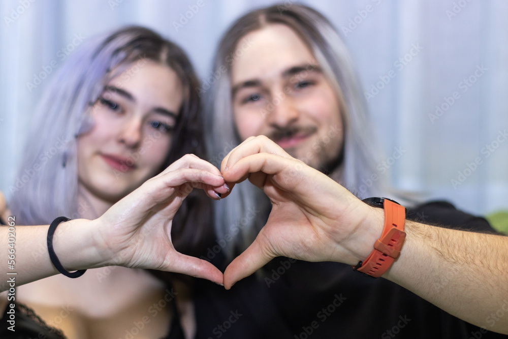 Couple in love sitting making a heart shape with their hands, Young ...