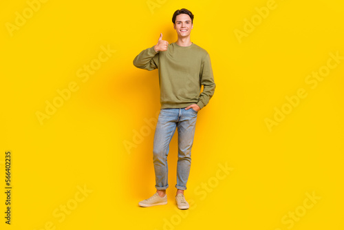 Full length photo of positive cheerful person hand finger demonstrate thumb up isolated on yellow color background © deagreez