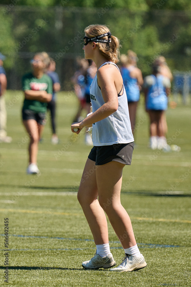 THE WOODLANDS, TEXAS - OCTOBER 2022: The Woodlands High School varsity lacrosse team is playing in a tournament at Alden Bridge Sports Park. The teenage girls are wearing white and green uniforms THE WOODLANDS, TEXAS - OCTOBER 2022: The Woodlands High School varsity lacrosse team is playing in a tournament at Alden Bridge Sports Park. The teenage girls are wearing white and green uniforms