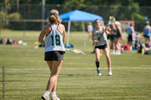 THE WOODLANDS, TEXAS - OCTOBER 2022: The Woodlands High School varsity lacrosse team is playing in a  tournament at  Alden Bridge Sports Park. The teenage girls are wearing white and green uniforms