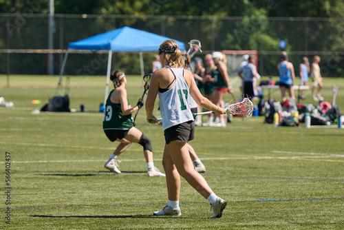 THE WOODLANDS, TEXAS - OCTOBER 2022: The Woodlands High School varsity lacrosse team is playing in a tournament at Alden Bridge Sports Park. The teenage girls are wearing white and green uniforms