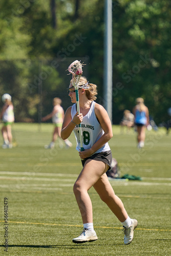 THE WOODLANDS, TEXAS - OCTOBER 2022: The Woodlands High School varsity lacrosse team is playing in a  tournament at  Alden Bridge Sports Park. The teenage girls are wearing white and green uniforms © Karina Eremina