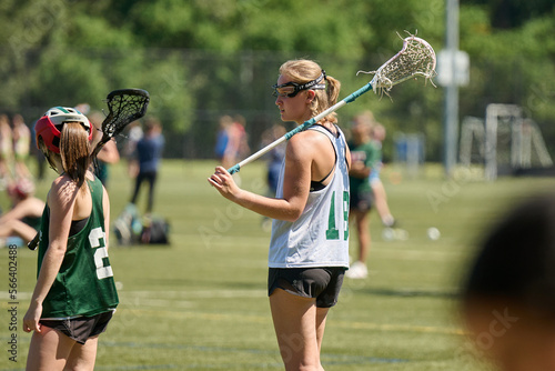 THE WOODLANDS, TEXAS - OCTOBER 2022: The Woodlands High School varsity lacrosse team is playing in a  tournament at  Alden Bridge Sports Park. The teenage girls are wearing white and green uniforms