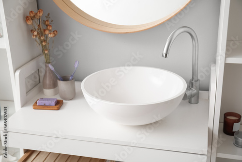 Table with sink  flowers and bath supplies in bathroom