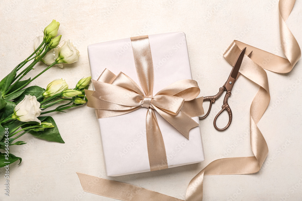 Gift box, beautiful eustoma flowers and scissors on light background. Women's Day celebration Gift box, beautiful eustoma flowers and scissors on light background. Women's Day celebration