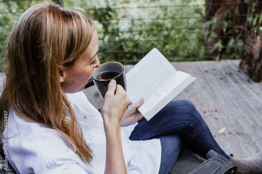 Obraz premium Hispanic woman reading a book in a morning and holding coffee cup on the terrace of a country house in Mexico Latin America 