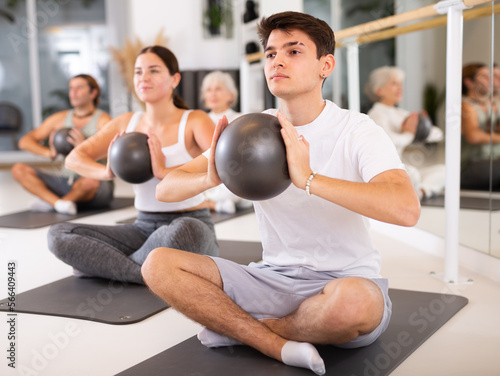 Canvastavla Slender young man engaging in pilates training with ball in gym room during trai