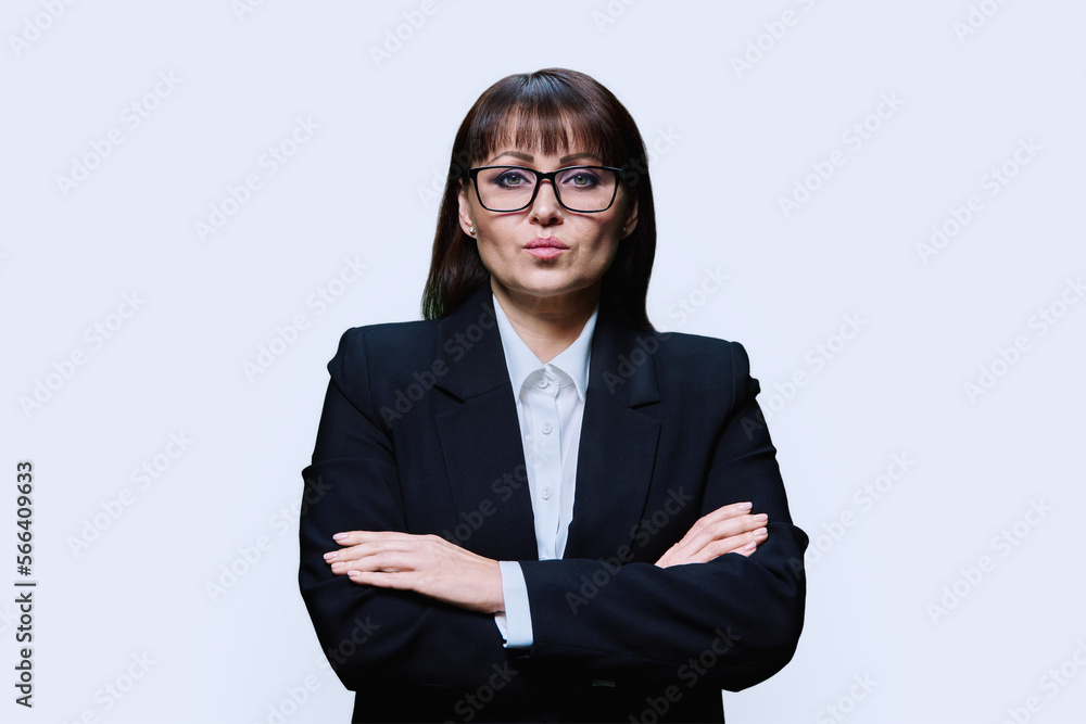 Confident serious middle aged business woman in jacket on light background Confident serious middle aged business woman in jacket on light background