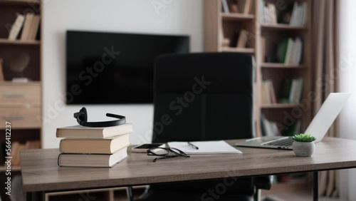 Wallpaper Mural Shot of modern workplace, office with laptop, books, papers, eyeglasses, headset on wood table with large tv on white wall background. Torontodigital.ca