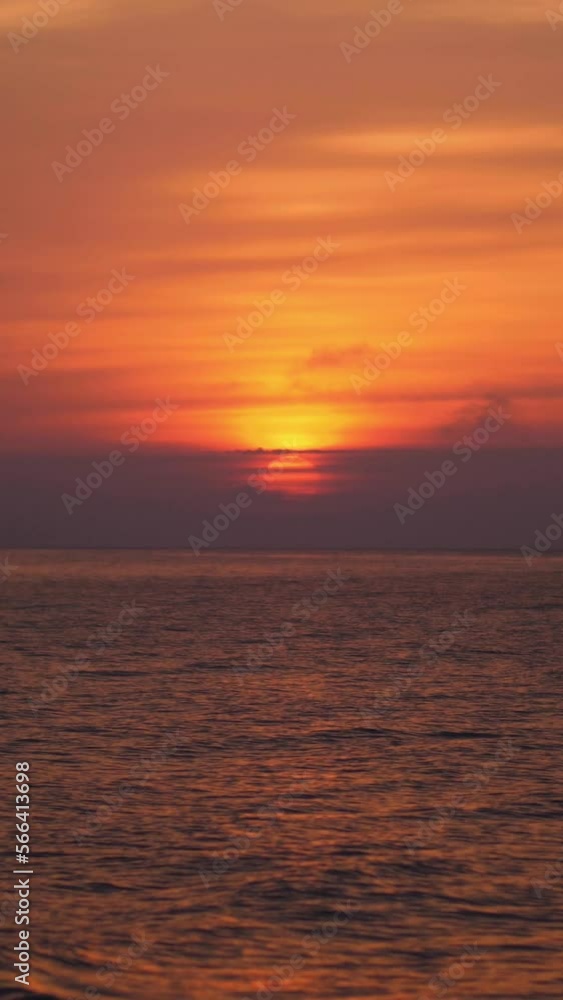 Vertical video of beautiful orange sunset over rhythmic sea wave as the sun reflects off the water. Vertical video of beautiful orange sunset over rhythmic sea wave as the sun reflects off the water.