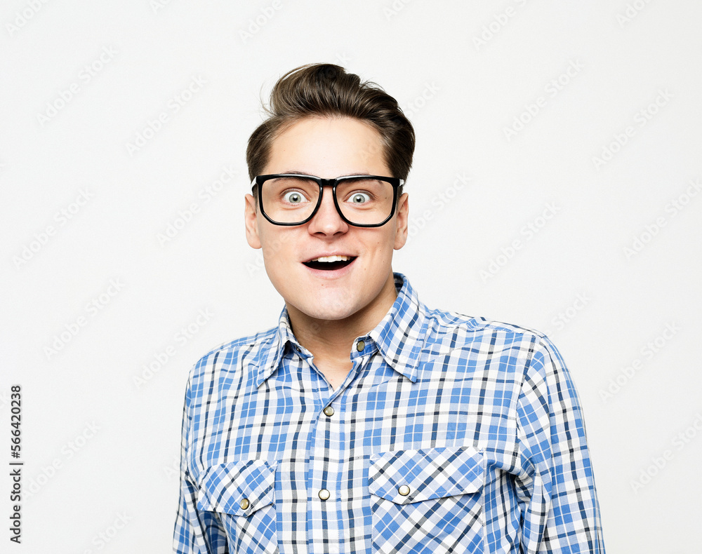 young man wearing eyewear and plaid shirt with emotions on his face young man wearing eyewear and plaid shirt with emotions on his face