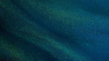 Abstract galaxy background. Golden glitter particles on a dark green background with blue hues. Golden dust particles magical stains.