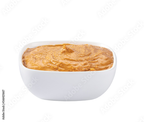 Creamy peanut butter in small bowl isolated on white background