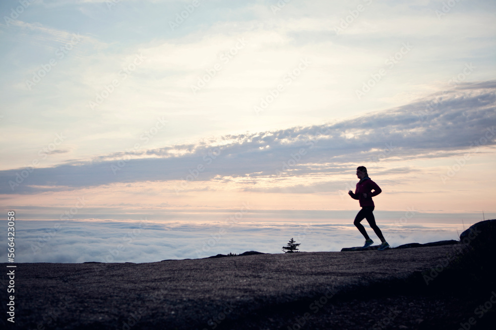 A woman runs at sunrise on Cadillac Mountain, Maine. A woman runs at sunrise on Cadillac Mountain, Maine.