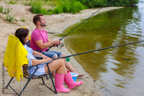 a married couple on a fishing trip.young man and woman are fishing, they are relaxing, they are enjoying food.a young modern couple is fishing on the river
