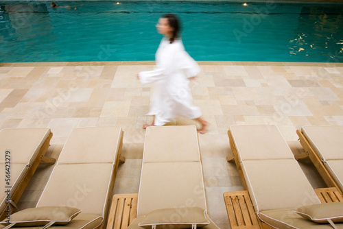 Woman in a white robe walking by the indoor pool at a spa, Stowe VT.