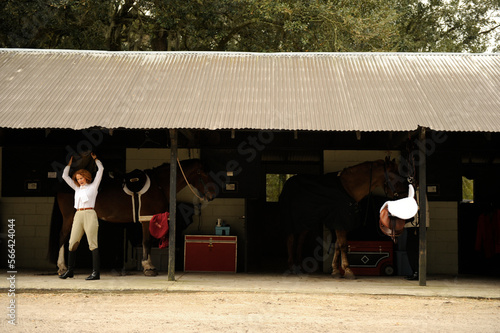 An equestrian dons her jacket in preparation for a traditional fox hunt at the stables. photo