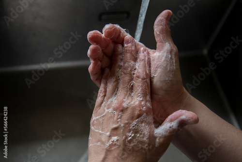 Someone washing their hands in the sink photo