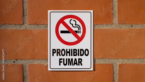No smoke sign on brick wall in Spanish