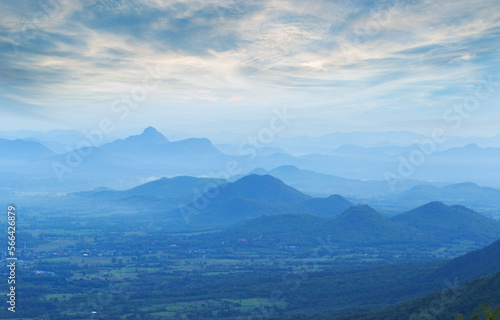 landscape with silhouettes of blue mountains with mist and cold sunlight.