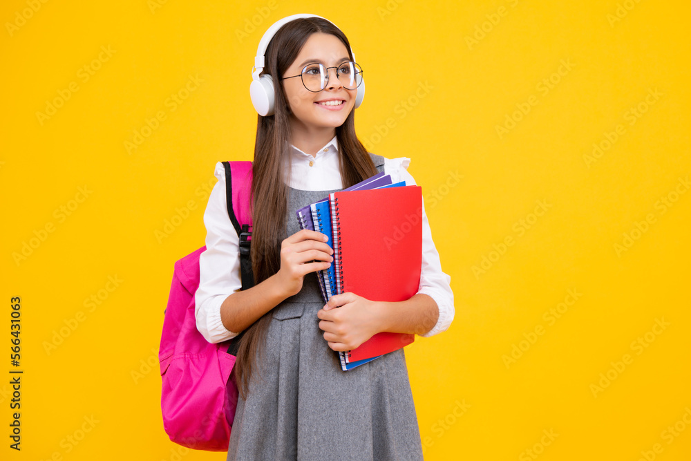 School girl, teenage student in headphones and books on isolated studio background. School kids with backpack. Happy face, positive and smiling emotions of teenager girl. School girl, teenage student in headphones and books on isolated studio background. School kids with backpack. Happy face, positive and smiling emotions of teenager girl.