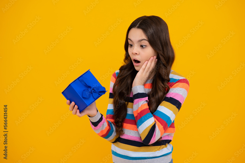 Amazed teenager. Child with gift present box on isolated studio background. Gifting for kids birthday. Excited teen girl. Amazed teenager. Child with gift present box on isolated studio background. Gifting for kids birthday. Excited teen girl.