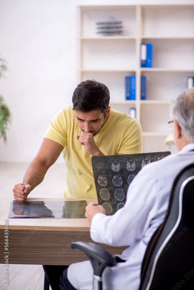 Fototapeta premium Young male patient visiting old male doctor
