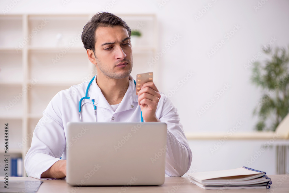 Young male doctor suggesting pills at the hospital Young male doctor suggesting pills at the hospital