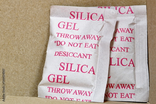 Two Silica gel packets in box porous desiccant substance packing absorb humidity moisture. photo