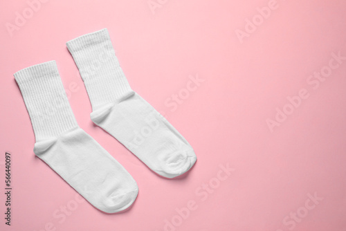 Pair of white socks on pink background, flat lay. Space for text