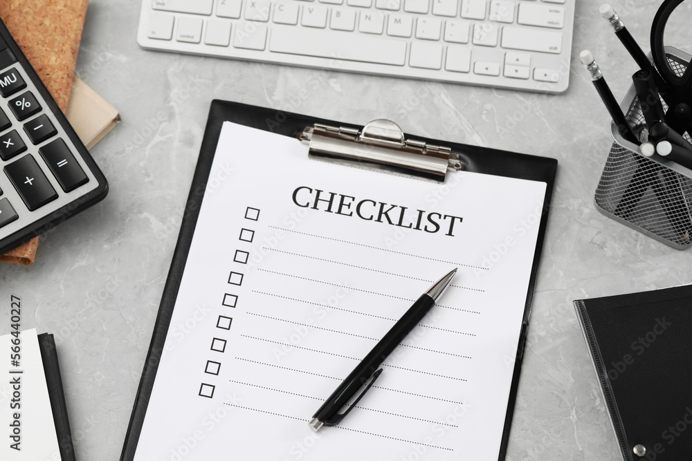 Clipboard with inscription Checklist and pen on grey marble table, above view Clipboard with inscription Checklist and pen on grey marble table, above view