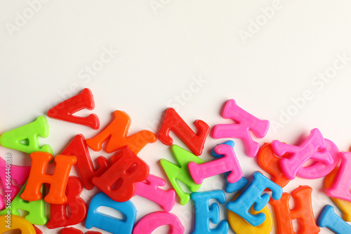 Many colorful magnetic letters on white background, flat lay. Space for text