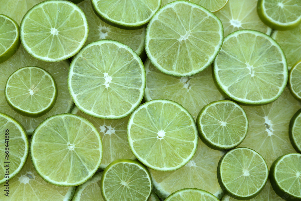 Fresh lime slices as background, top view