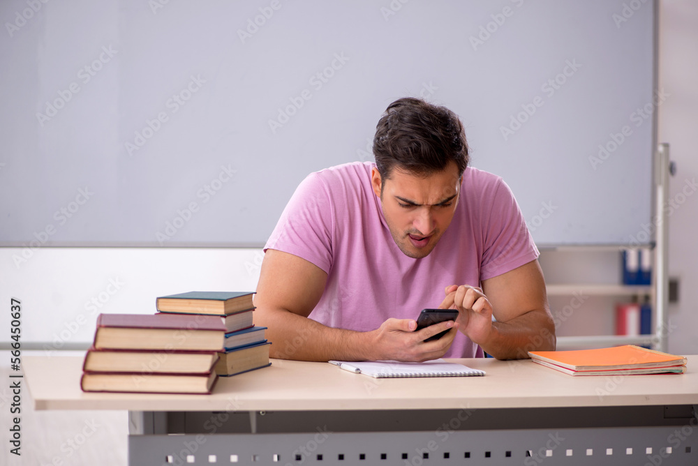 Young male student preparing for exams in the classroom Young male student preparing for exams in the classroom