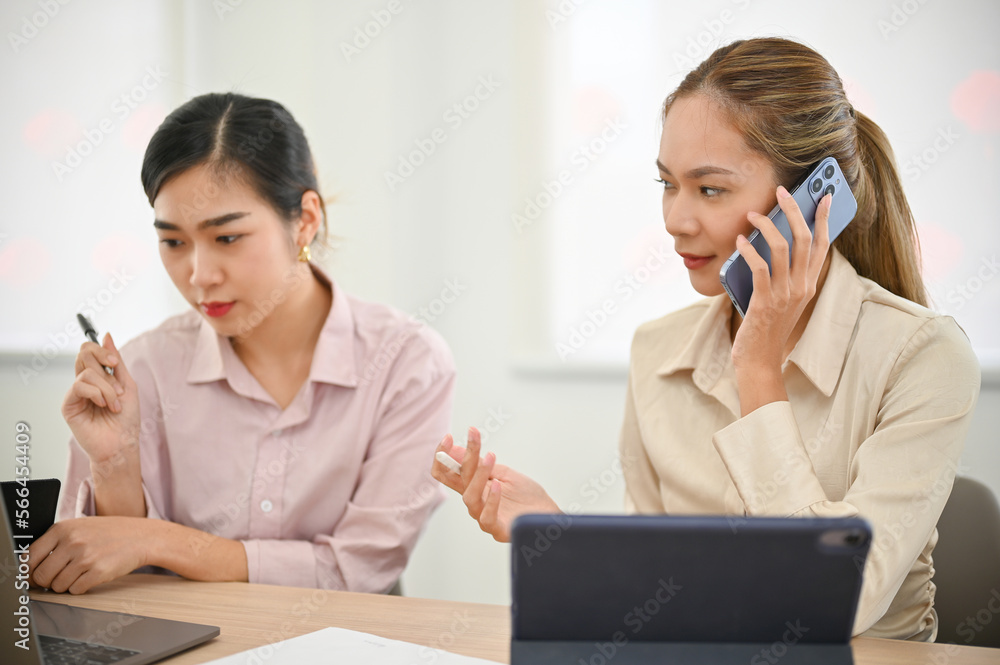 Two focused asian businesswoman working together in the office. Two focused asian businesswoman working together in the office.