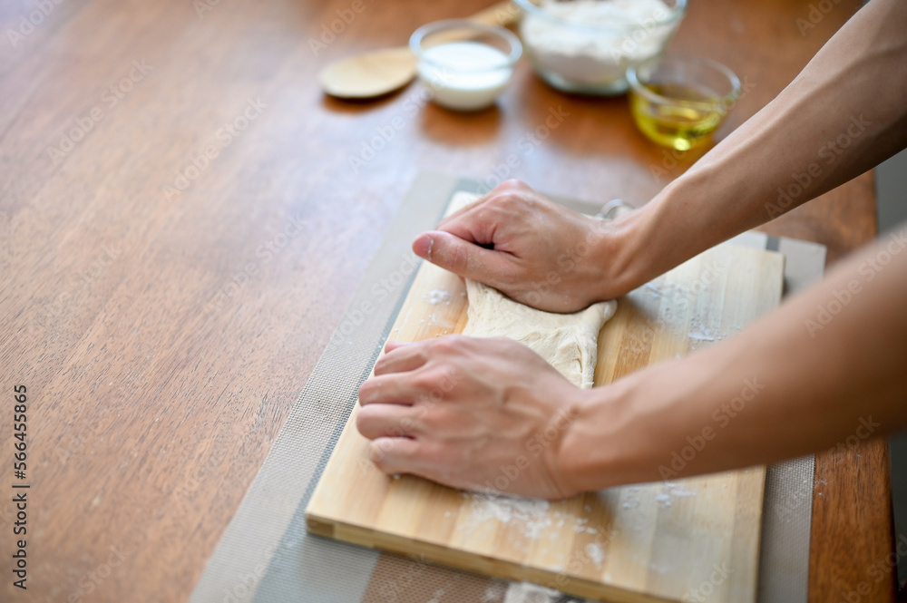 Close-up hand image of a male baker kneading raw dough, preparing dough for his pastry Close-up hand image of a male baker kneading raw dough, preparing dough for his pastry