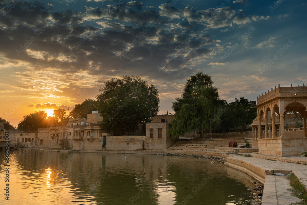 Spectacular sunset at Gadisar lake,Jaisalmer,Rajasthan, India. Setting sun and colorful clouds in the sky with view of the Gadisar lake. Connected with Indira Gandhi Canal for continuous water supply.