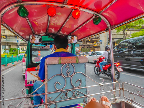 01 23 2023 - Bangkok, Thailand. Woman riding in a Tuk tuk cabin in streets of Bangkok with a personal driver during a traffic