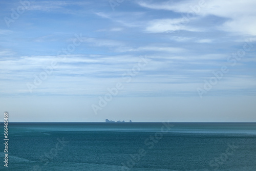 Blue tropical seascape background with island in the distance