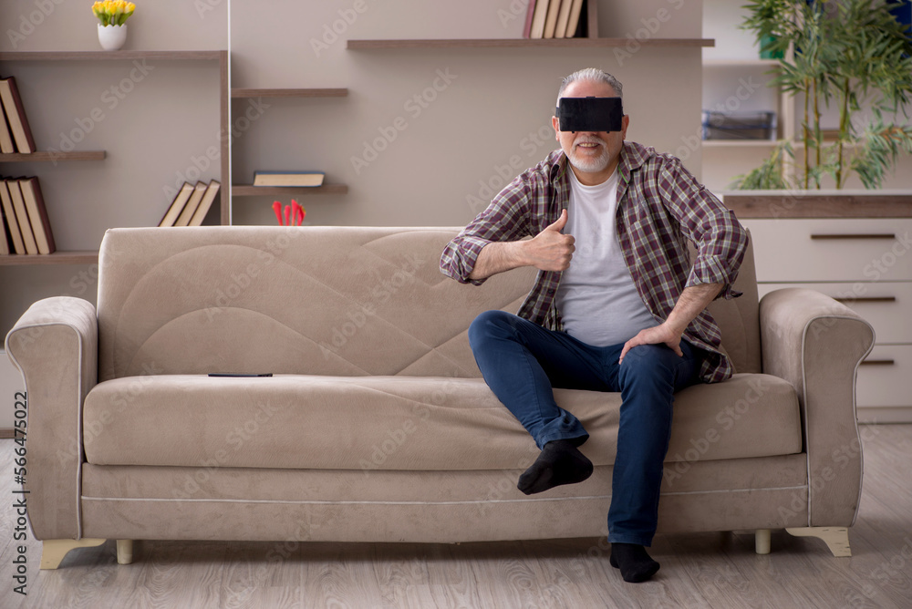 Old man wearing virtual glasses at home Old man wearing virtual glasses at home
