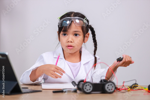 Asian little girl students learn at home by coding robot cars in STEM, STEAM, mathematics engineering science technology computer code in robotics for kids' concepts.