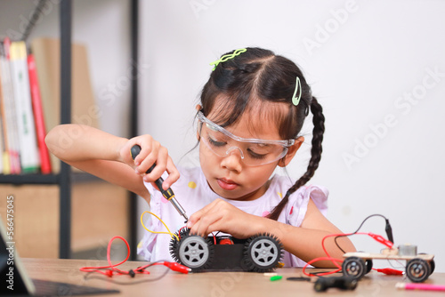 Asian little girl students learn at home by coding robot cars in STEM, STEAM, mathematics engineering science technology computer code in robotics for kids' concepts.