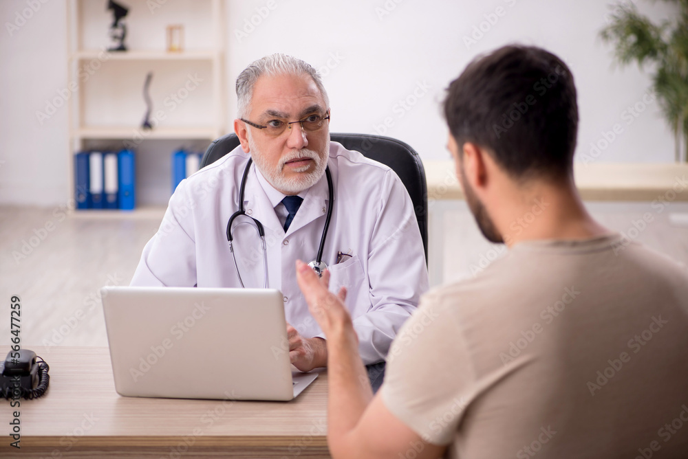 Young male patient visiting old male doctor Young male patient visiting old male doctor
